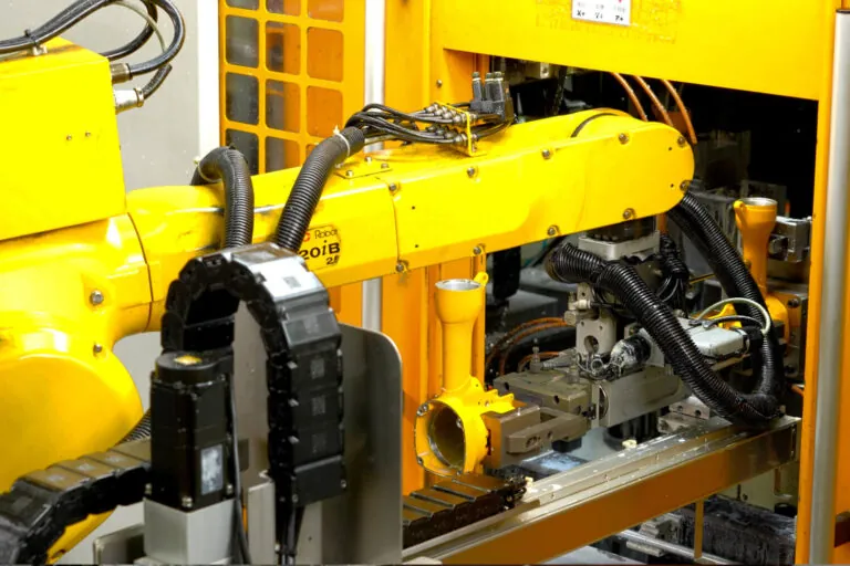 Automated production cell processing overmolded aluminum tool bodies to ensure consistent grip quality and molecular adhesion.