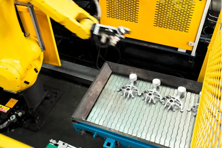 High-pressure aluminum die casting station featuring a Fanuc robotic arm for automated extraction and consistent cycle timing.