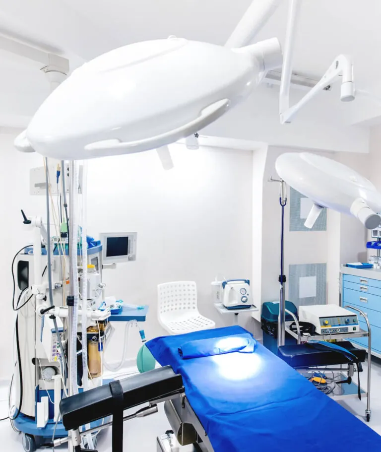 Precision aluminum die cast surgical lighting arm and equipment mounts installed in a modern sterile operating room environment.