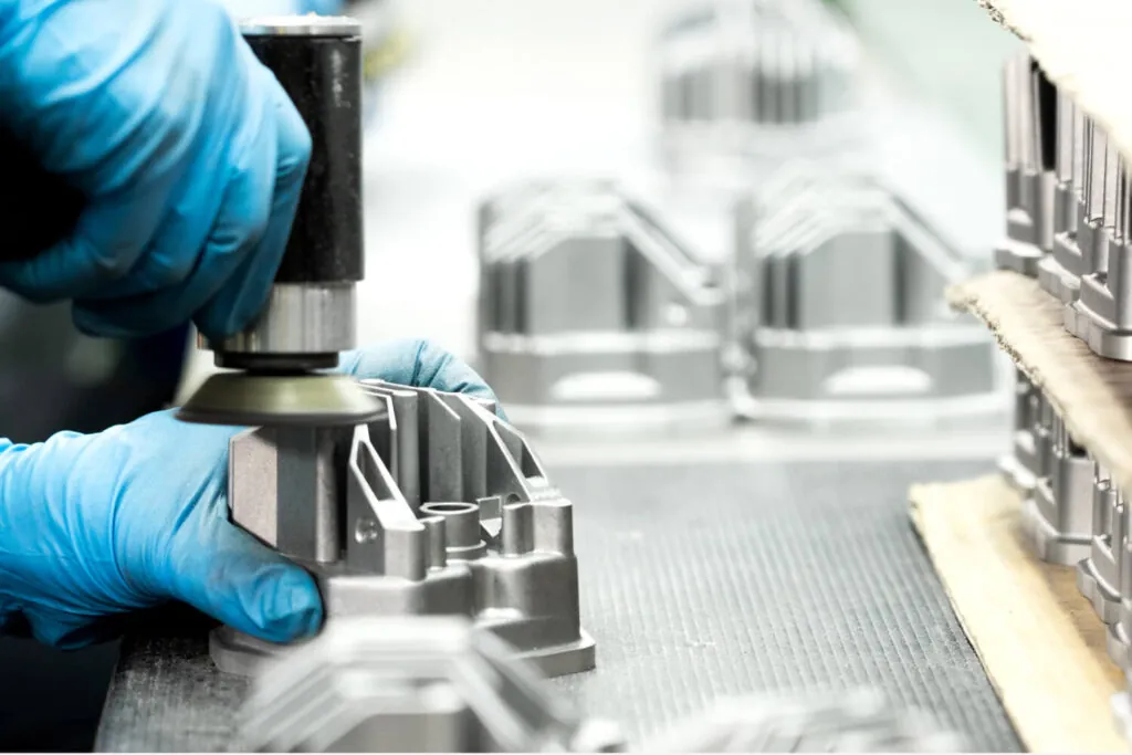 JoinCast 技術人員對鋁合金壓鑄照明零件進行手工拋光與表面前處理，確保高品質塗裝與外觀一致性