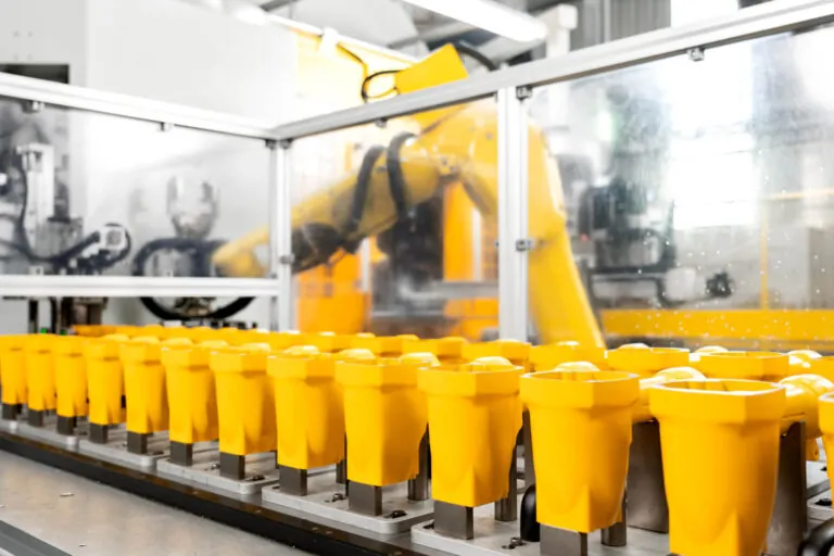 Automated robotic production line performing secondary CNC machining on yellow pneumatic tool bodies to achieve ±0.01 mm tolerances.
