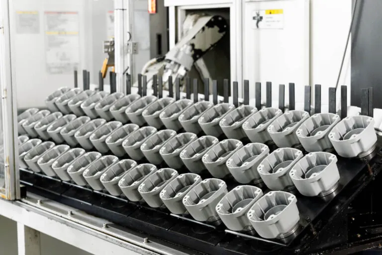 Batch of high-volume aluminum die cast pneumatic tool components ready for vertically integrated surface treatment and finishing.