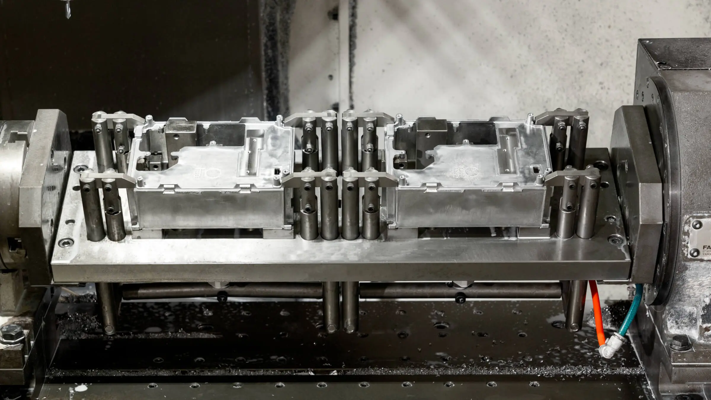 Specialized CNC machining jig securing aluminum electronic enclosures for high-accuracy milling operations.