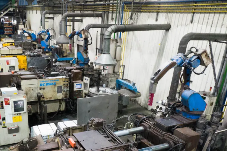 Overview of JoinCast’s automated die casting facility in Taiwan featuring a row of high-pressure cold chamber machines integrated with robotic extractors.