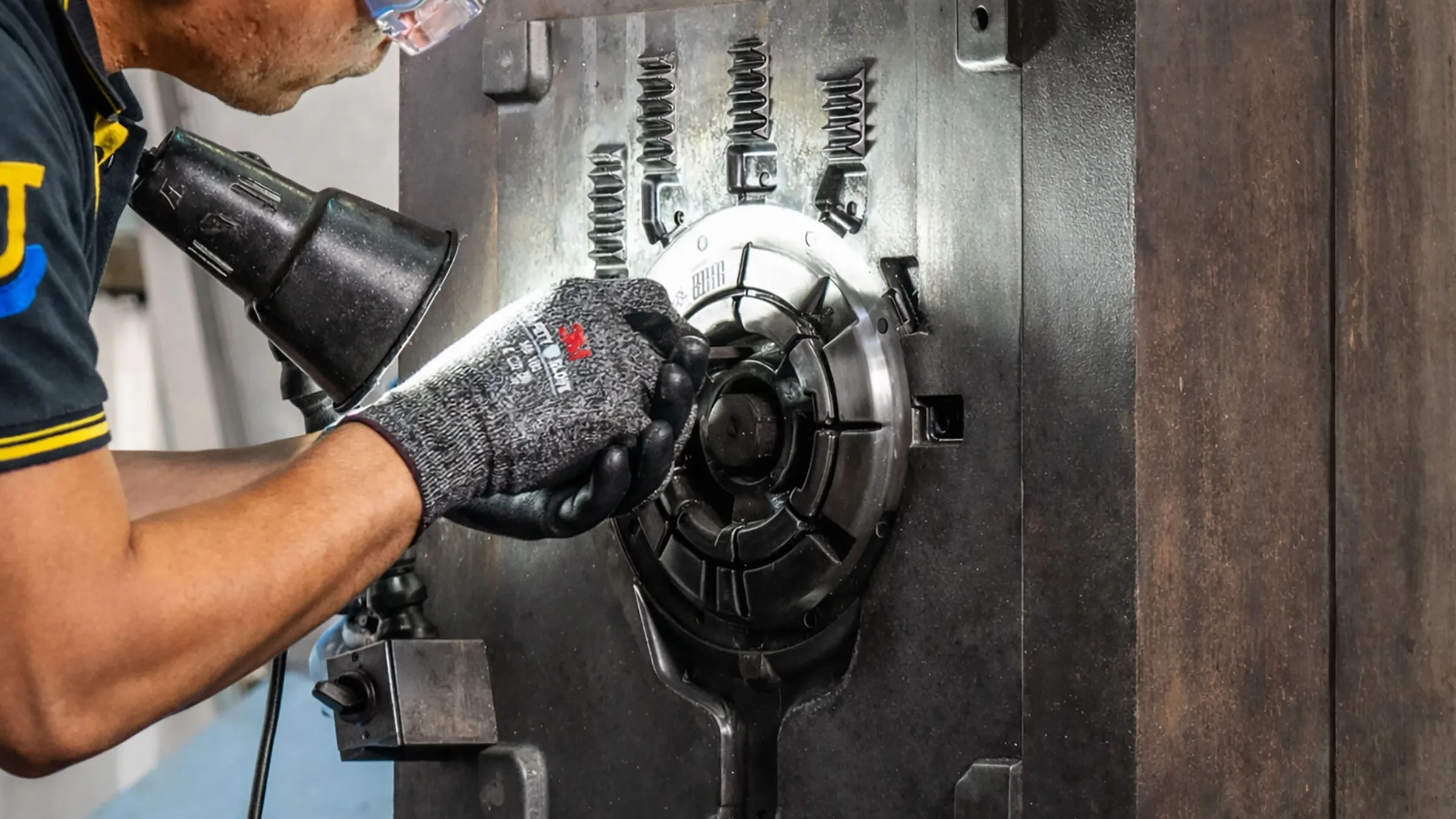 Expert JoinCast technician performing precision maintenance and manual adjustment on a high-pressure aluminum die casting mold.